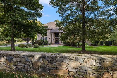 This home is nestled on 3.46 acres of privacy surrounded by lush landscaping and beautiful custom built stone walls. | Image 2