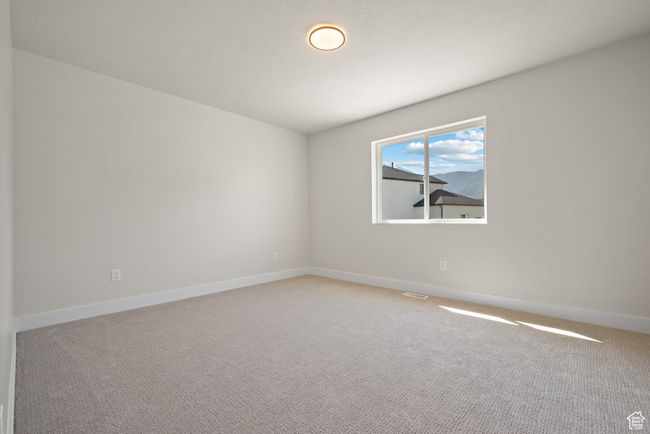 Unfurnished bedroom featuring light colored carpet, a closet, and a textured ceiling | Image 26