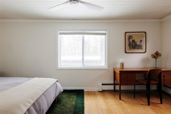 Bedroom with a baseboard heating unit, light hardwood / wood-style flooring, and ceiling fan | Image 12