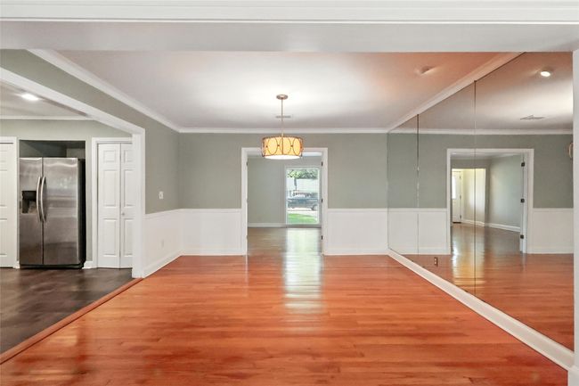 Living room with a fireplace with flush hearth, visible vents, french doors, and ornamental molding | Image 8