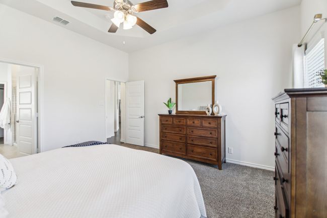 Carpeted bedroom featuring visible vents, baseboards, and a ceiling fan | Image 16