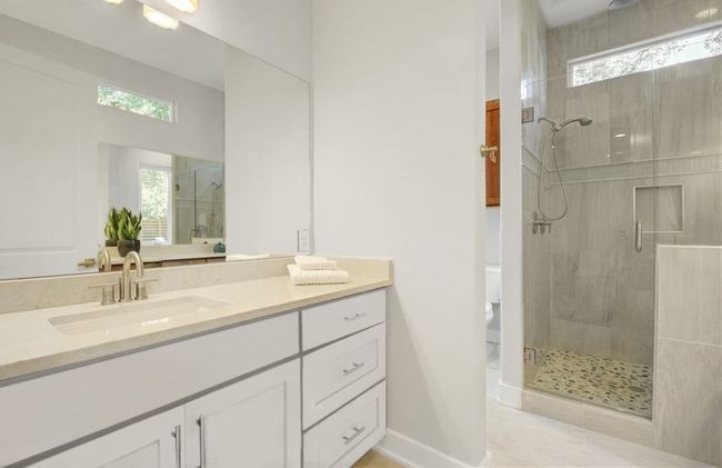 Bathroom featuring vanity, baseboards, a stall shower, and toilet | Image 16