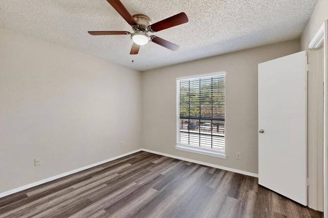 Unfurnished room with a textured ceiling, dark wood-style flooring, and ceiling fan | Image 22
