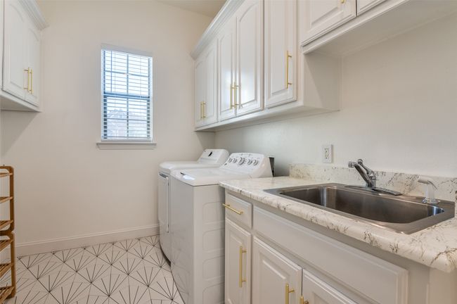 Laundry room featuring baseboards, washing machine and dryer, cabinet space, and a sink | Image 31