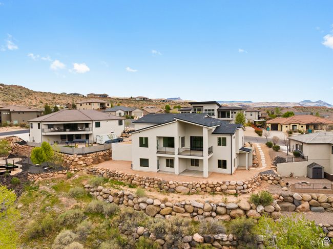 Rear view of property with a balcony, a fenced backyard, a residential view, stucco siding, and a mountain view | Image 38