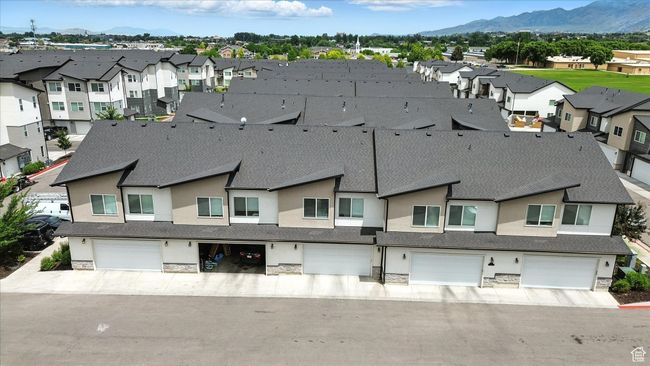Exterior space featuring stone siding, a garage, a residential view, and a mountain view | Image 26