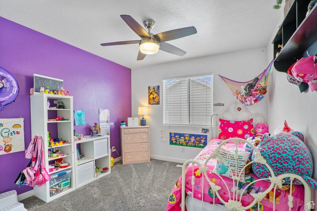 Carpeted bedroom with a textured ceiling, baseboards, and ceiling fan | Image 17