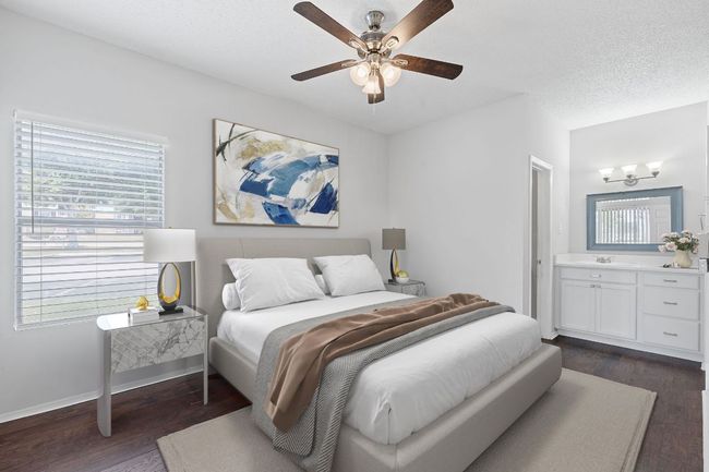 VIRTUALLY STAGED Bedroom featuring a sink, dark wood-style flooring, baseboards, and multiple windows | Image 11