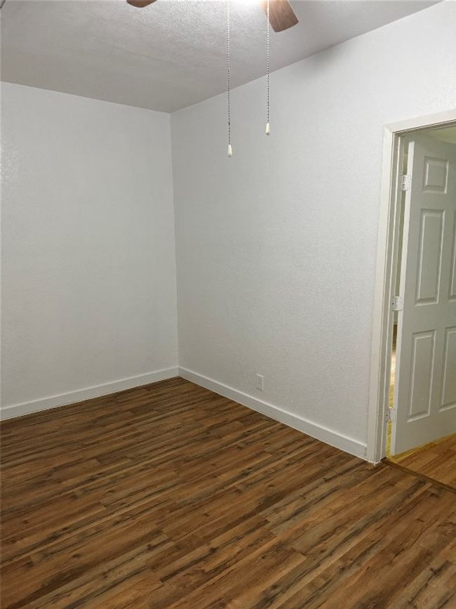 Spare room with ceiling fan, dark wood finished floors, and a textured ceiling | Image 6