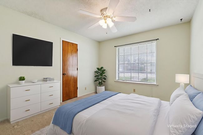 Bedroom featuring light carpet, ceiling fan, and a textured ceiling | Image 23