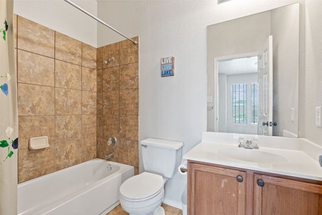Full bathroom featuring toilet, vanity, and shower / bathtub combination with curtain | Image 22