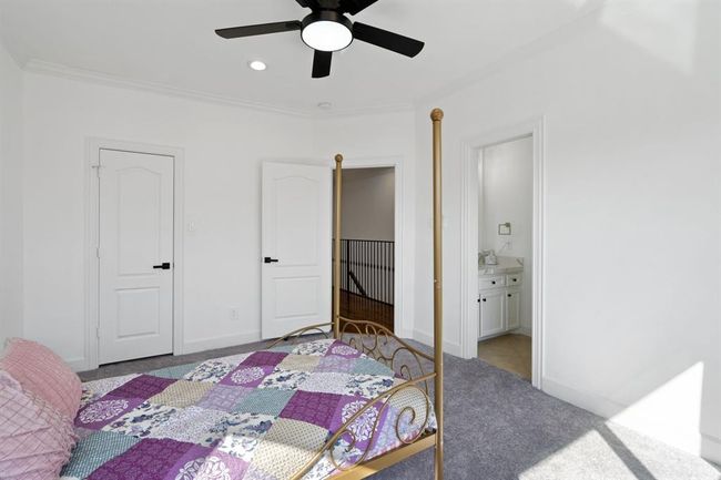 Spacious secondary bedroom featuring a walk-in closet, oversized windows, and convenient access to a Jack and Jill bathroom. Natural light fills the space, creating a bright and inviting atmosphere. | Image 40
