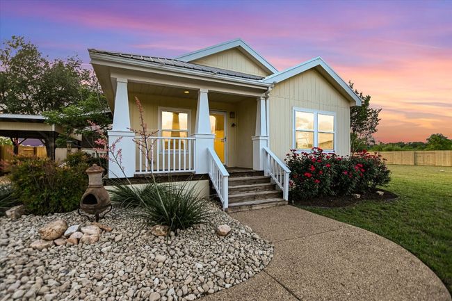 Bungalow-style home featuring metal roof, covered porch, fence, and a front yard | Image 4