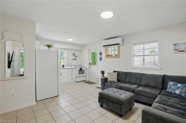 Living area with an AC wall unit and light tile patterned floors | Image 19