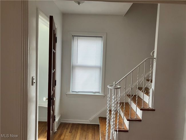 Staircase with hardwood / wood-style floors, baseboards, and a healthy amount of sunlight | Image 11