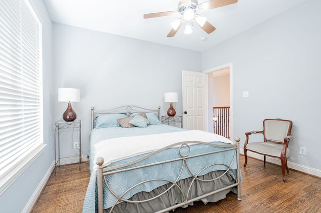 Bedroom with wood finished floors, baseboards, ceiling fan, and multiple windows | Image 22