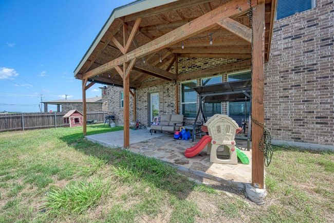 Fenced backyard with a patio area and a storage unit | Image 31