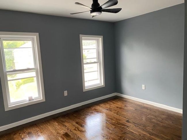 Spare room with plenty of natural light, dark wood finished floors, and a ceiling fan | Image 18