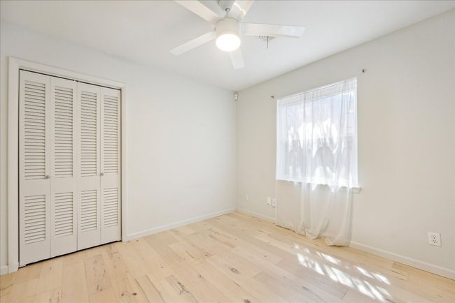 Unfurnished bedroom featuring ceiling fan, a closet, baseboards, and wood finished floors | Image 21