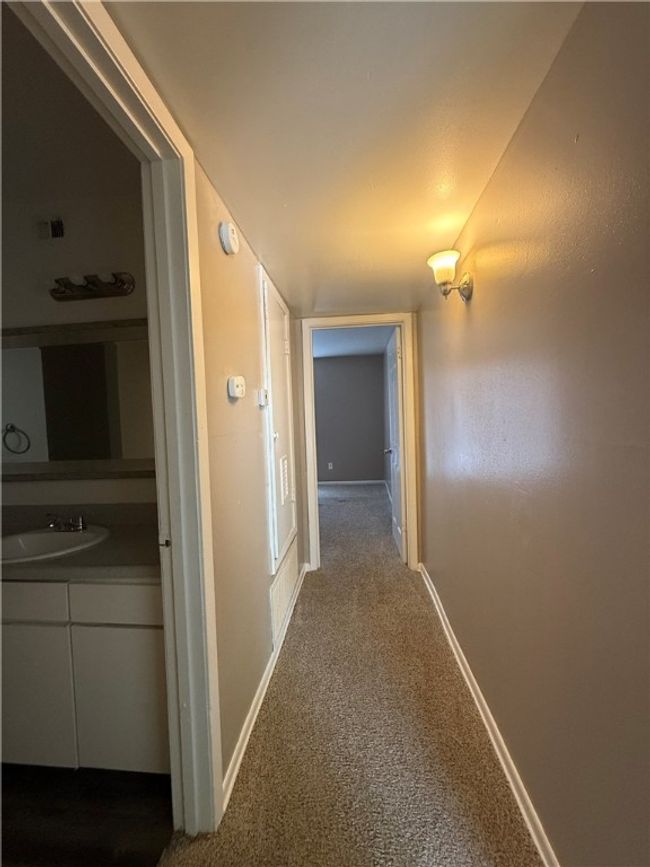 Corridor with a sink and dark carpet | Image 7