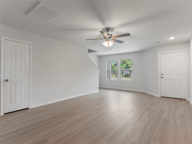 Bright and spacious living area featuring a modern ceiling fan for comfort. | Image 4