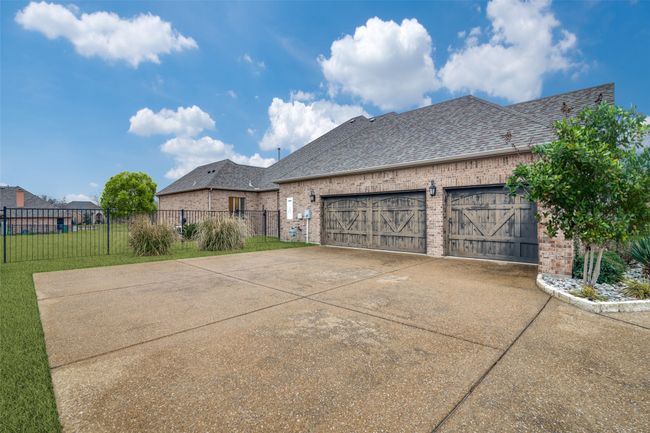 Full-sized 3 car garage with wooden garage doors. There is also storage space inside the garage. This parking area can accommodate additional parking | Image 31