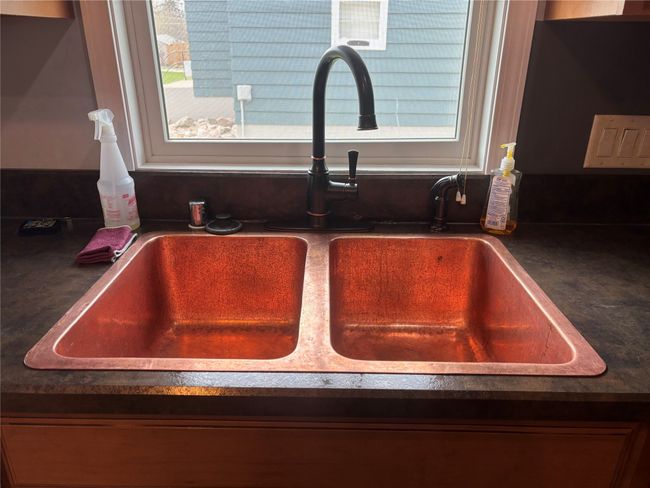 Kitchen view of a sink and dark countertops | Image 16
