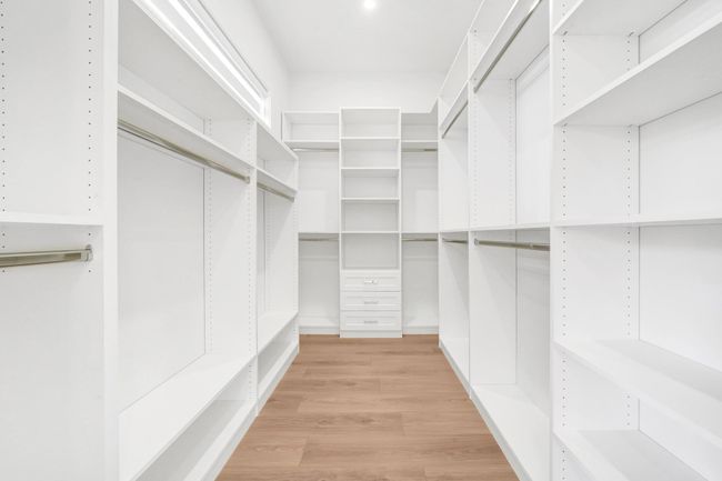 Walk in closet with light wood finished floors | Image 18