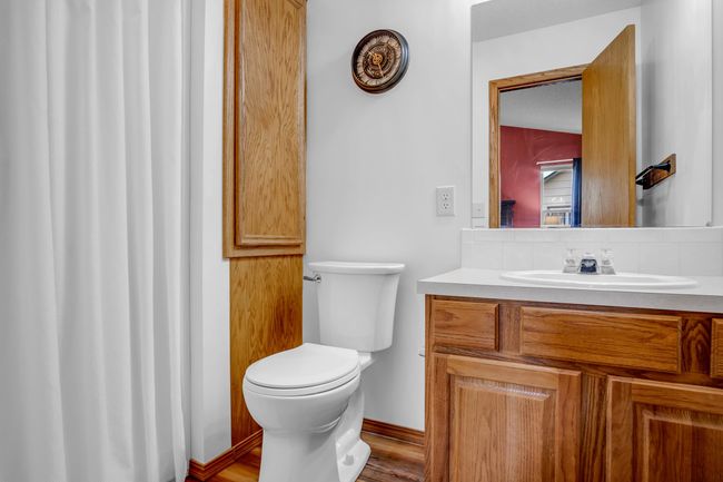 Bathroom featuring tasteful backsplash, toilet, vanity, and wood finished floors | Image 20