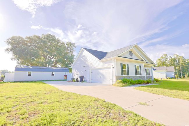 View of front of home with a front yard, an attached garage, concrete driveway, and brick siding | Image 30