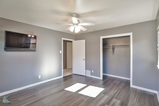 Unfurnished bedroom featuring dark hardwood / wood-style flooring, a closet, and ceiling fan | Image 19