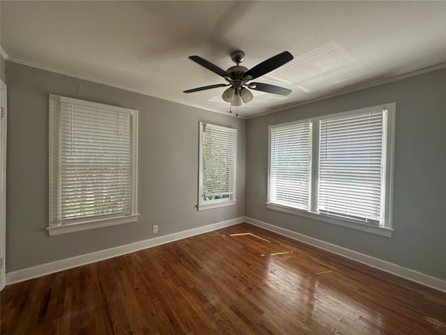 Unfurnished room featuring wood finished floors, baseboards, and crown molding | Image 4