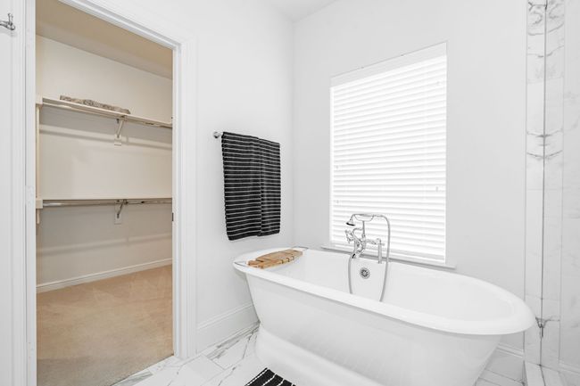 Full bathroom featuring a soaking tub and a walk in closet | Image 22