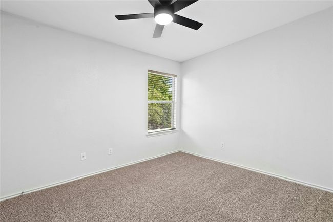 Carpeted empty room featuring a ceiling fan and baseboards | Image 20