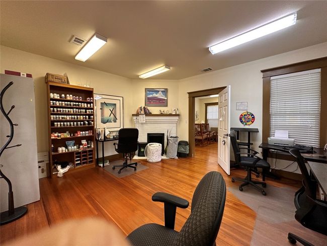 Office space featuring wood finished floors and a fireplace | Image 13