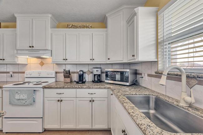 The kitchen offers an undermount S/S, single bowl sink and electric range oven. | Image 13