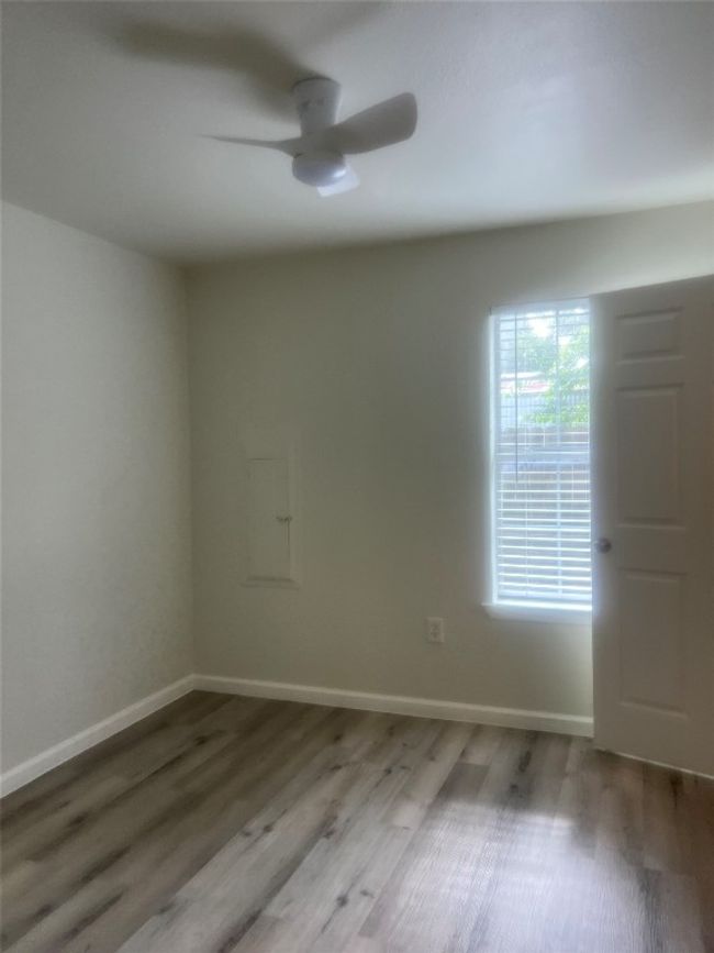 Empty room featuring a ceiling fan and wood finished floors | Image 13