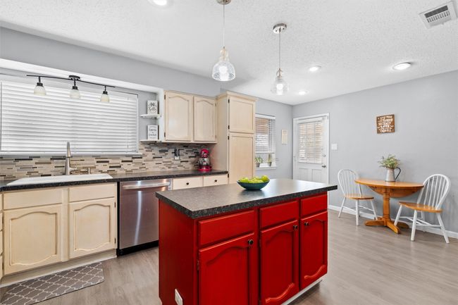 Spacious kitchen with island storage, featuring a breakfast bistro dining area | Image 9