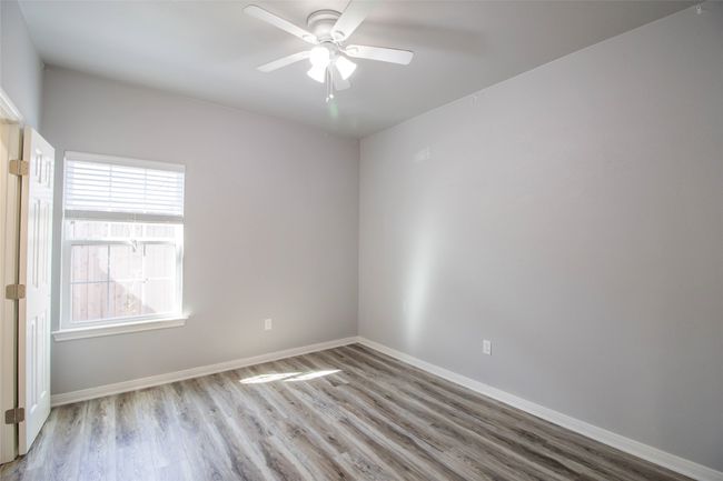 Empty room with wood finished floors and ceiling fan | Image 9