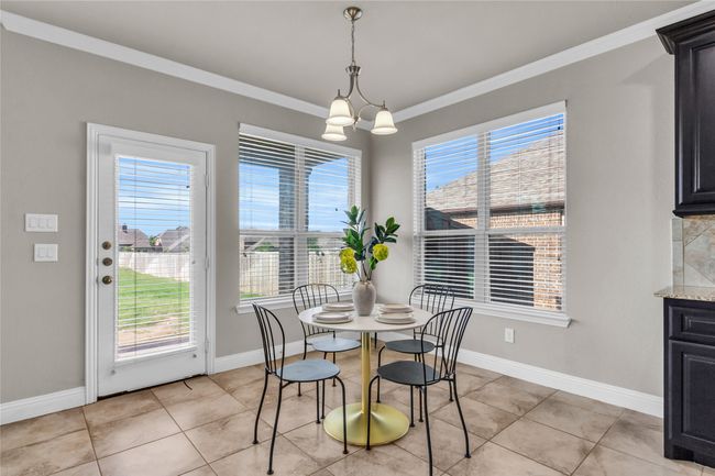 Dining space with crown molding, plenty of natural light, baseboards, and light tile patterned flooring | Image 8