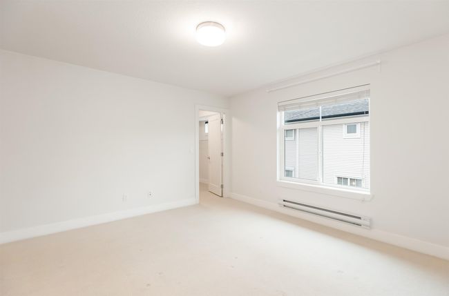Spare room featuring a baseboard heating unit, baseboards, and carpet | Image 17