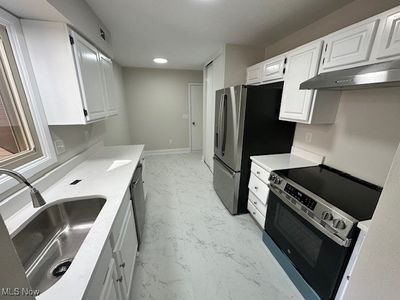 Kitchen with white cabinets, stainless steel appliances, and sink | Image 2