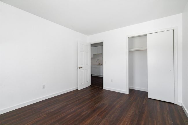 Unfurnished bedroom featuring dark wood-style floors, a closet, baseboards, and closet | Image 11