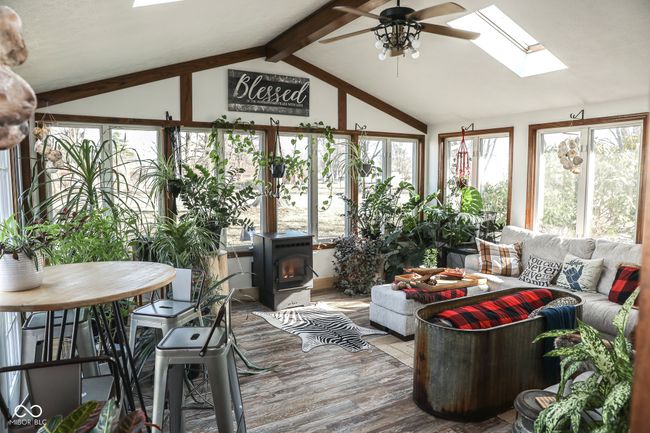 sunroom with vaulted ceiling with skylight, a wood stove, and ceiling fan | Image 31
