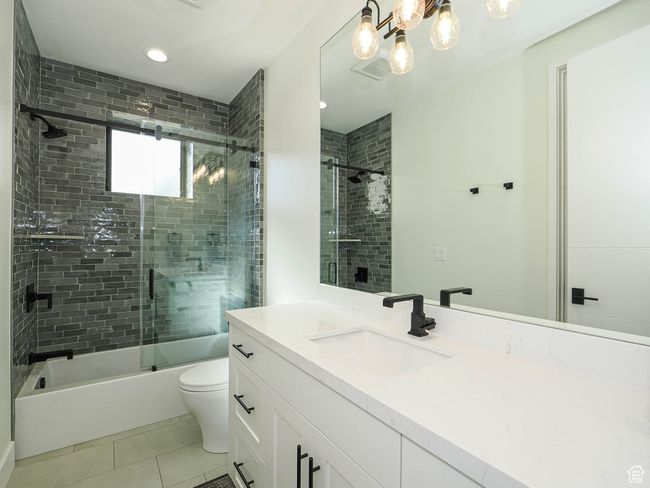Bathroom with vanity, shower / bath combination with glass door, tile patterned flooring, and recessed lighting | Image 77