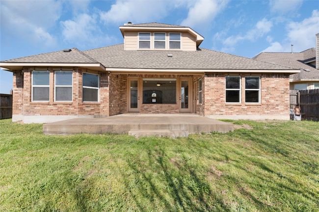 Rear view of property featuring a patio, brick siding, a lawn, and fence | Image 40