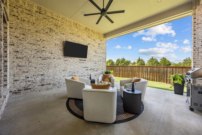 Fenced backyard with a ceiling fan, a patio, and a grill | Image 33