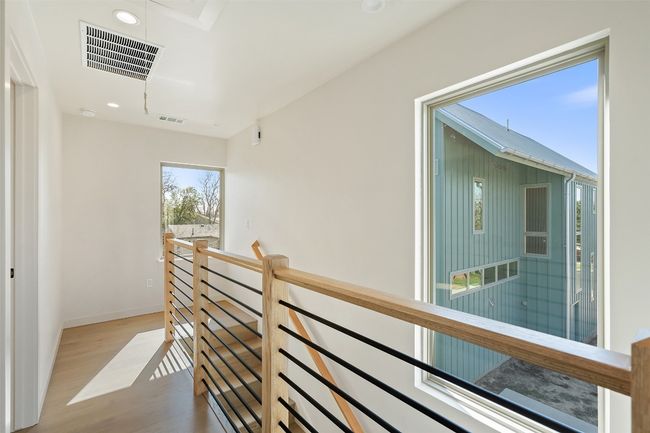 Hall with wood finished floors, an upstairs landing, visible vents, and recessed lighting | Image 31