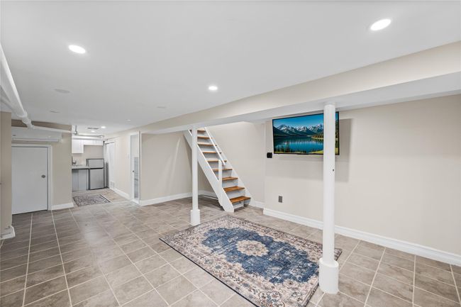 Finished basement featuring stairs, recessed lighting, light tile patterned floors, baseboards, and refrigerator | Image 17