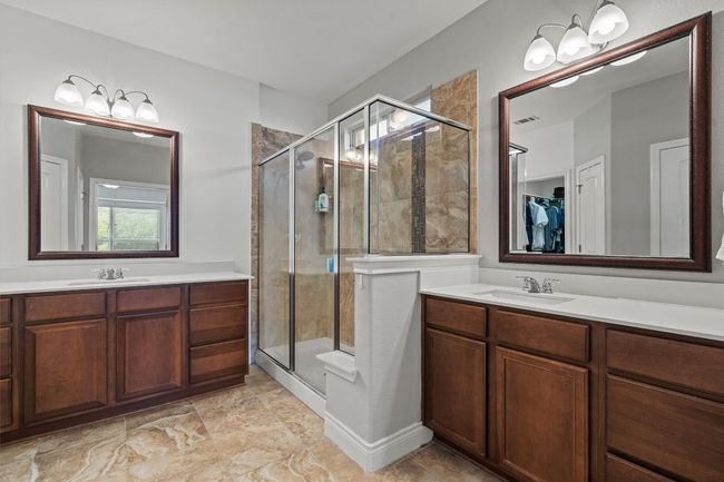 Bathroom featuring a stall shower, two vanities, and a walk in closet | Image 14